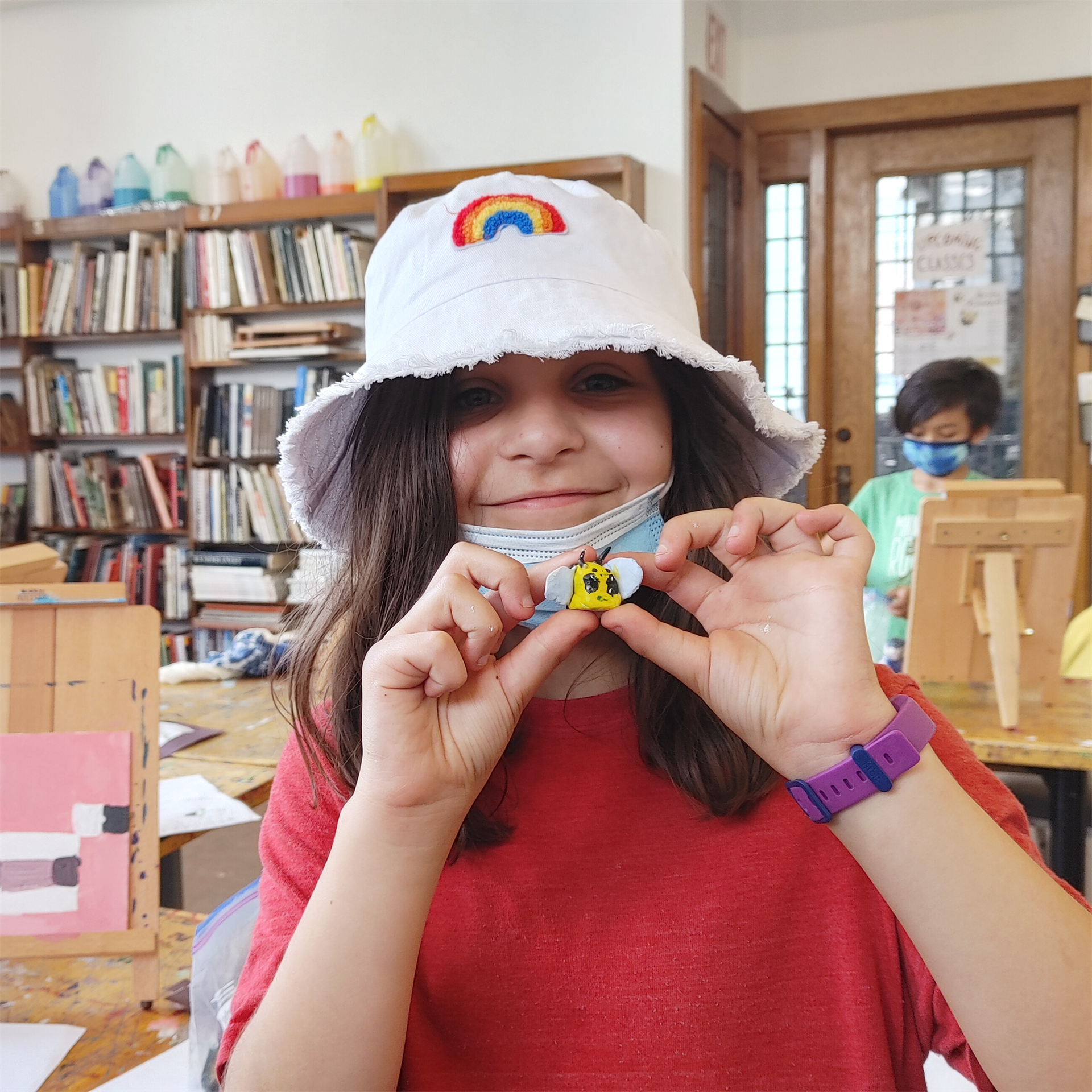 Child in DAI classroom holding a small clay Minecraft bee