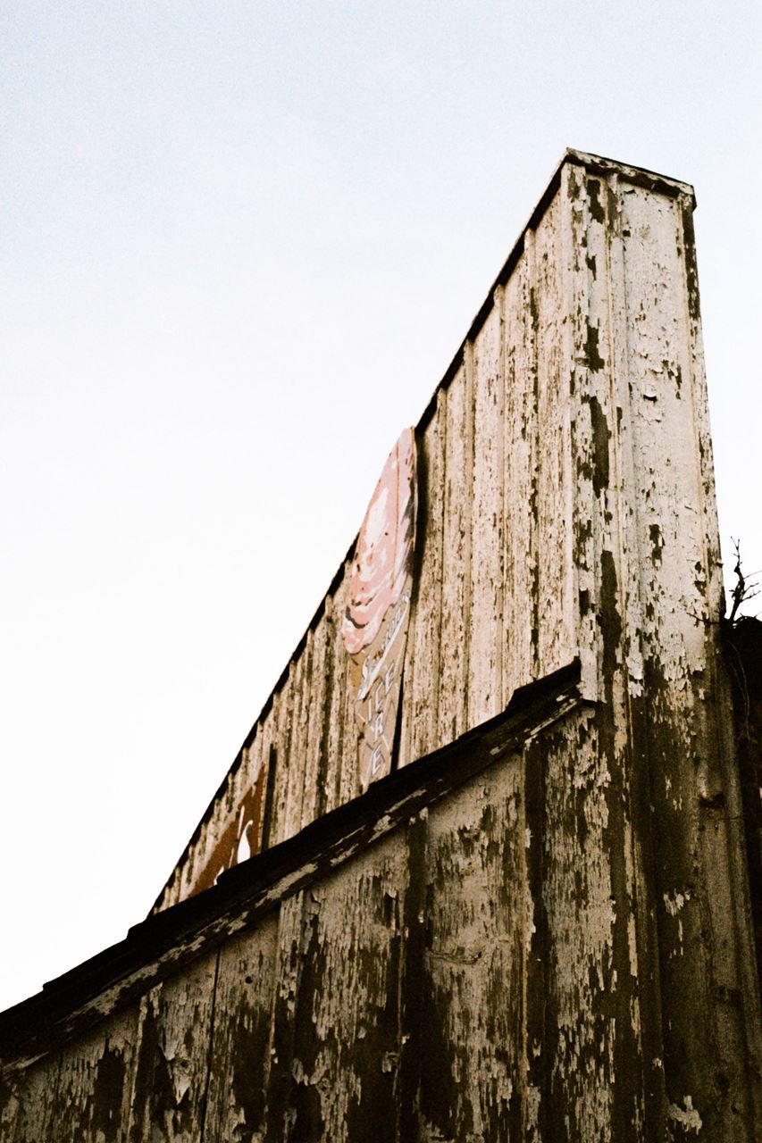 Roof corner detail of building with peeling white paint. Josalyn Dehncke, “06,” 35mm film