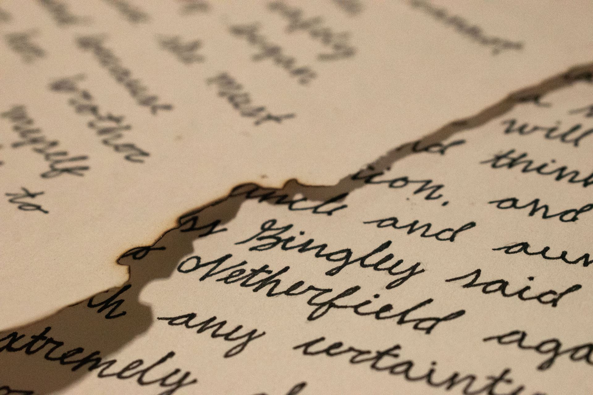 Close-up photo of paper with handwriting and burnt edges. Mackenzie Oswell, “Jane's Letter,” matte paper, 8.5"x11"